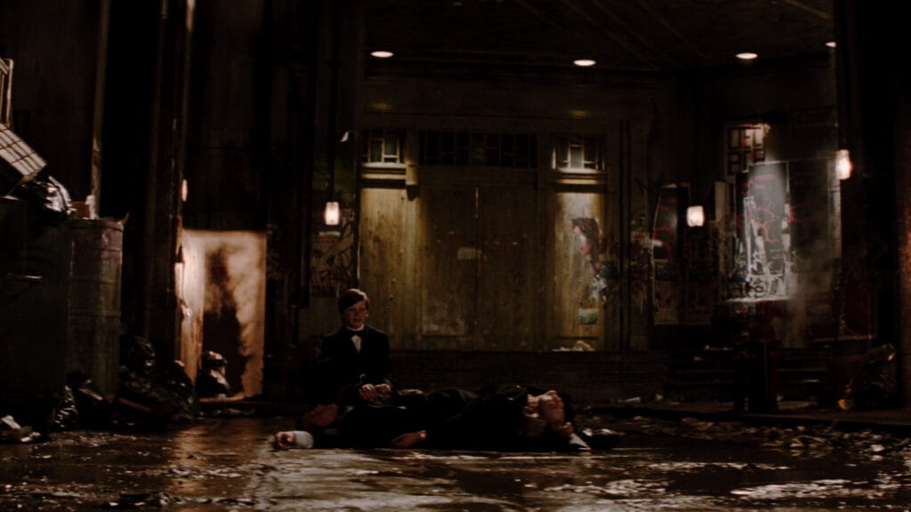 Imagen de la pelicula batman begins donde un pequeño bruce wayne esta de rodillas triste por el destino que tuvieron sus padres